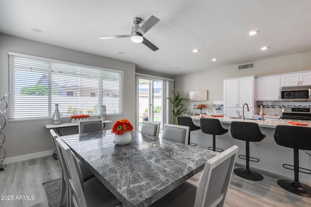 dining room with recessed lighting, light wood finished floors, visible vents, a ceiling fan, and baseboards