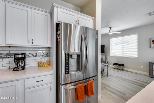 kitchen with tasteful backsplash, ceiling fan, stainless steel fridge with ice dispenser, white cabinets, and visible vents
