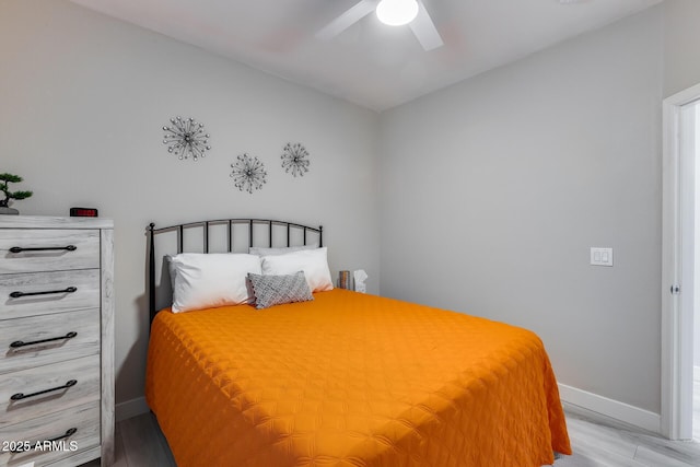 bedroom featuring baseboards, light wood-style floors, and ceiling fan