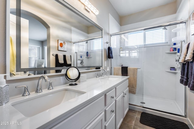 full bathroom with tile patterned floors, a sink, a shower stall, and double vanity