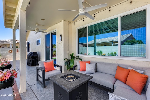 view of patio featuring fence, grilling area, a ceiling fan, and an outdoor living space with a fire pit