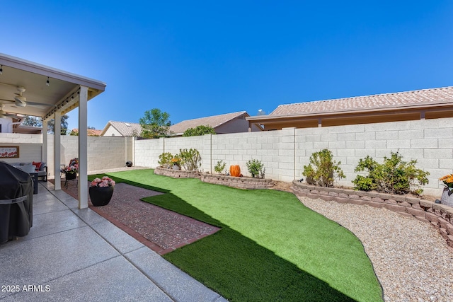 view of yard featuring a fenced backyard, a patio area, and ceiling fan