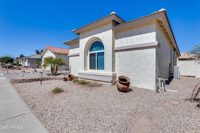 view of side of property featuring cooling unit and stucco siding
