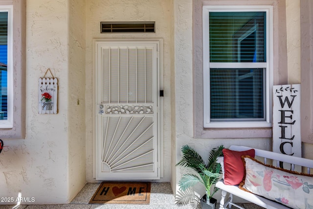 doorway to property featuring stucco siding