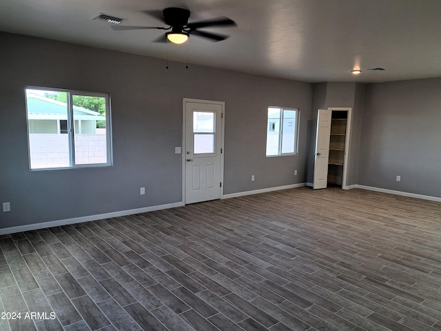 interior space featuring ceiling fan, a wealth of natural light, and dark hardwood / wood-style floors