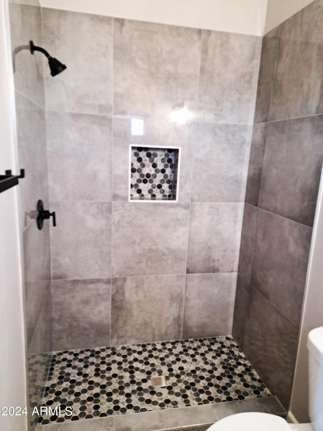 bathroom with toilet and tiled shower