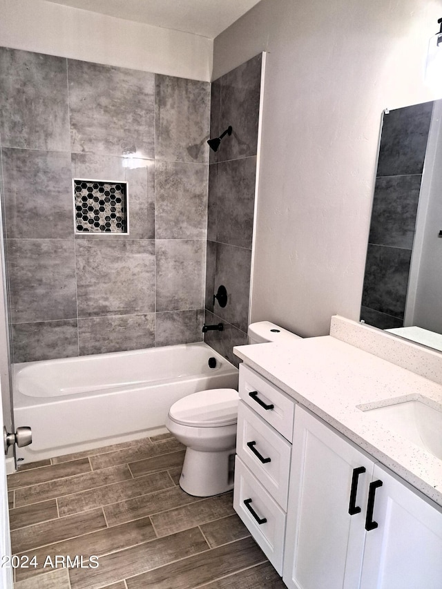 full bathroom with toilet, tiled shower / bath combo, and vanity