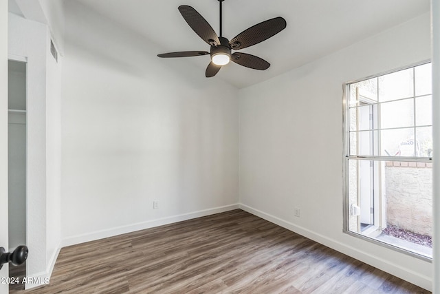 spare room with ceiling fan, a wealth of natural light, and hardwood / wood-style floors