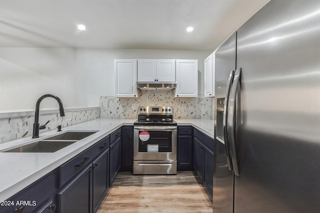 kitchen featuring sink, white cabinets, light hardwood / wood-style floors, backsplash, and appliances with stainless steel finishes