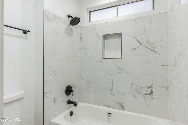 bathroom with toilet and tiled shower / bath combo