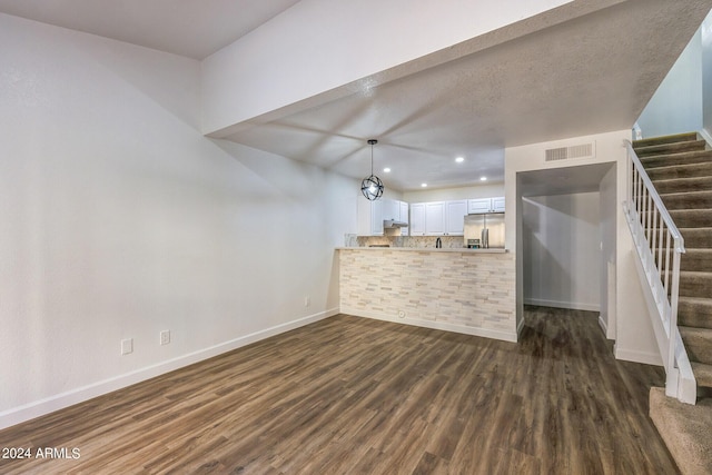 interior space with a textured ceiling and dark hardwood / wood-style floors