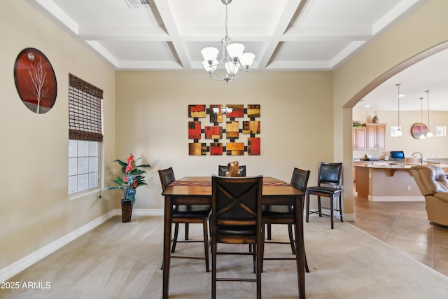 dining room featuring a chandelier, coffered ceiling, beamed ceiling, and light carpet