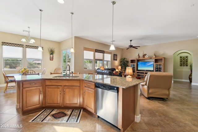 kitchen with light stone countertops, decorative light fixtures, sink, a kitchen island with sink, and stainless steel dishwasher