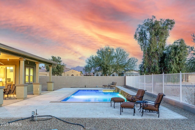 pool at dusk with a patio