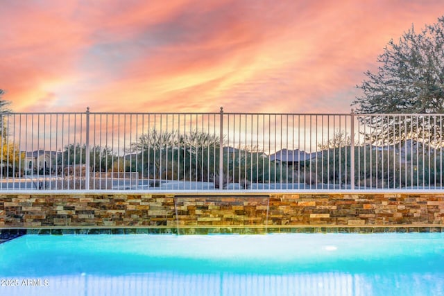 view of pool at dusk