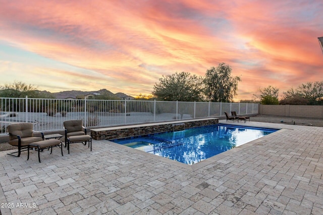 pool at dusk featuring a patio