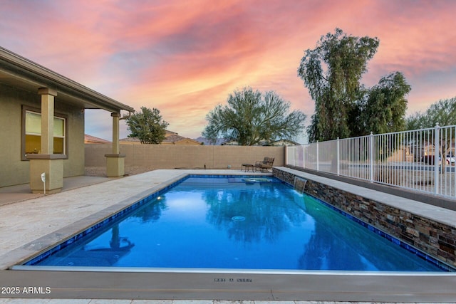 pool at dusk with a patio area