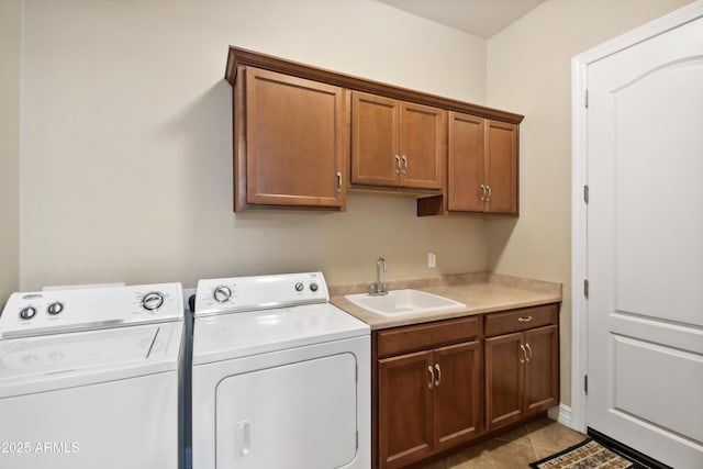 clothes washing area with cabinets, sink, light tile patterned floors, and separate washer and dryer