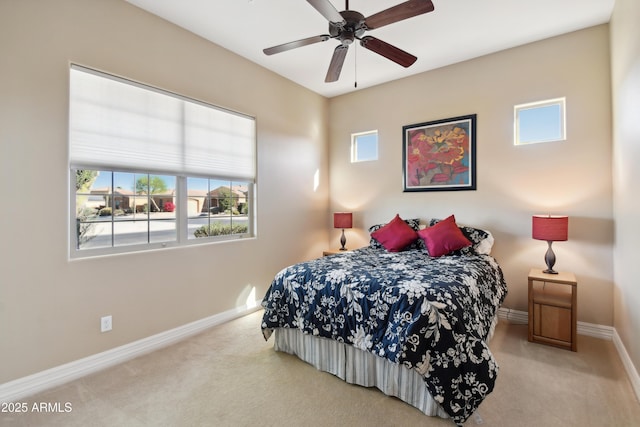 bedroom with multiple windows, light colored carpet, and ceiling fan