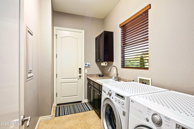 laundry area featuring cabinets, sink, washer and dryer, a textured ceiling, and light tile patterned flooring