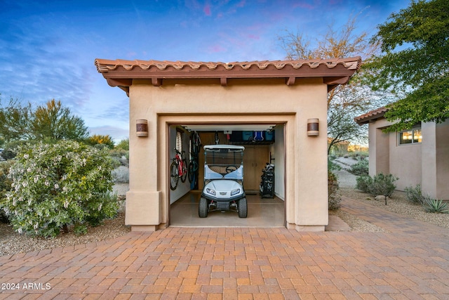 view of garage at dusk