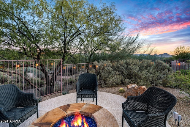 patio terrace at dusk featuring a mountain view and an outdoor fire pit