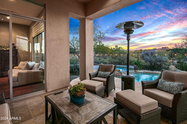 patio terrace at dusk featuring a fenced in pool and pool water feature