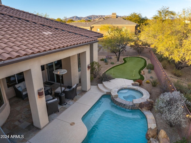 view of swimming pool featuring an in ground hot tub, a mountain view, and a patio area