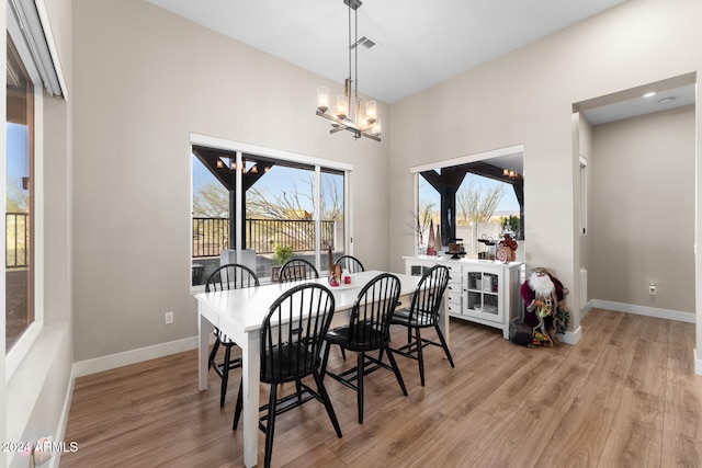 dining space featuring light hardwood / wood-style flooring and a chandelier