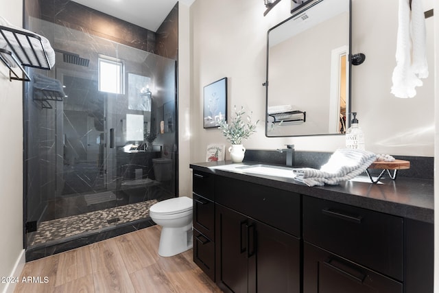 bathroom featuring vanity, toilet, a shower with shower door, and wood-type flooring