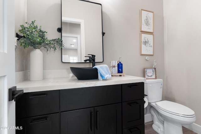 bathroom with hardwood / wood-style floors, toilet, and vanity