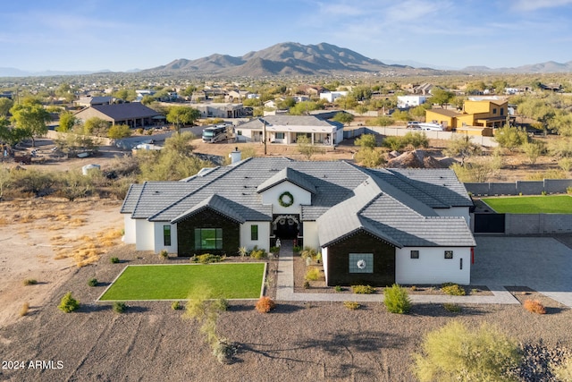 view of front of home with a mountain view and a front lawn