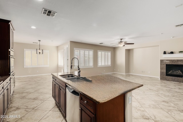 kitchen with a sink, open floor plan, and stainless steel dishwasher