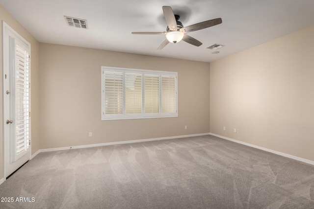 empty room with baseboards, visible vents, and light colored carpet