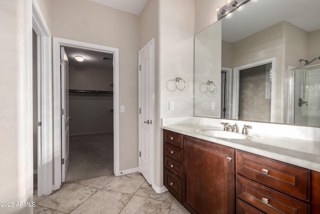 full bath with a stall shower, visible vents, tile patterned flooring, a walk in closet, and vanity