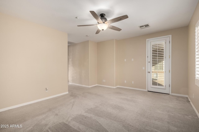 unfurnished room with light carpet, a ceiling fan, visible vents, and baseboards