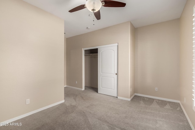 unfurnished bedroom with light carpet, a closet, and baseboards