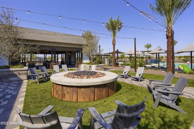 exterior space featuring a gazebo, a patio area, a lawn, and a fire pit