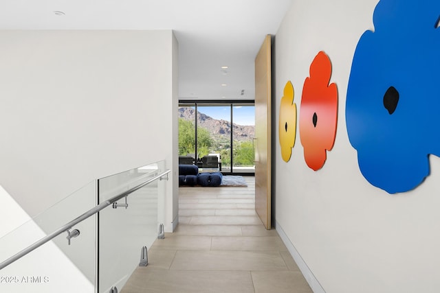 corridor with floor to ceiling windows and a mountain view