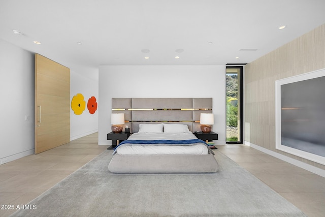 bedroom with light tile patterned floors and a wall of windows