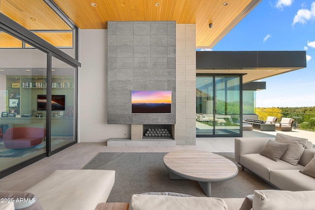 living room with a tiled fireplace, floor to ceiling windows, and wood ceiling