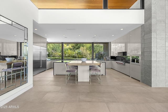 kitchen with white cabinetry, a center island, stainless steel built in fridge, and plenty of natural light