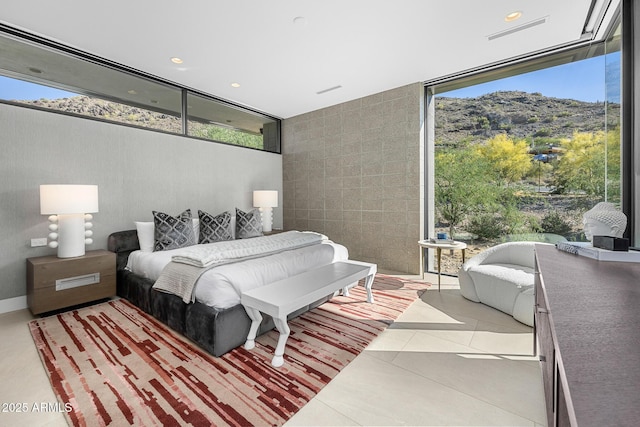 tiled bedroom with a wall of windows