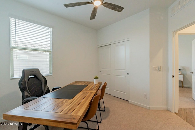 carpeted home office featuring ceiling fan