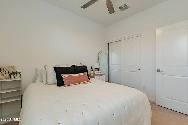 bedroom featuring ceiling fan, light colored carpet, and a closet