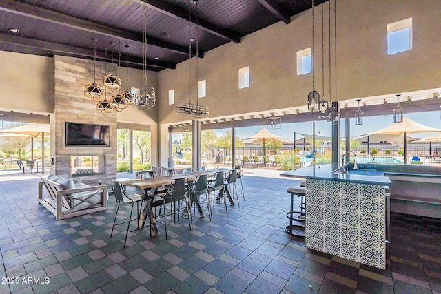 view of patio / terrace with a multi sided fireplace and a bar