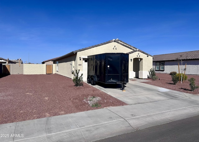ranch-style home with an attached garage, driveway, stucco siding, fence, and a tile roof