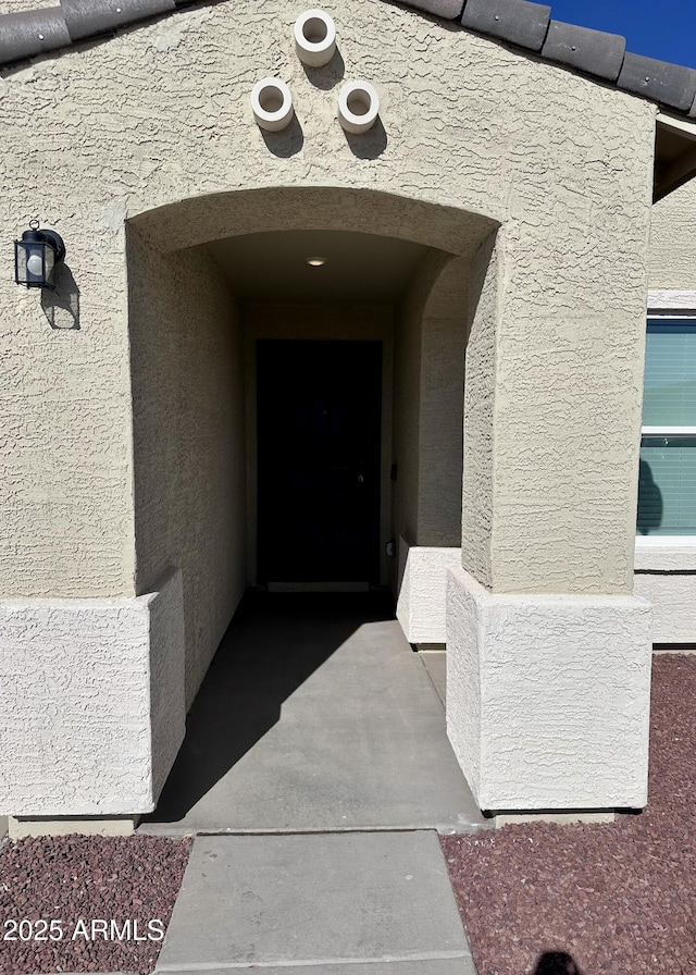 property entrance with stucco siding