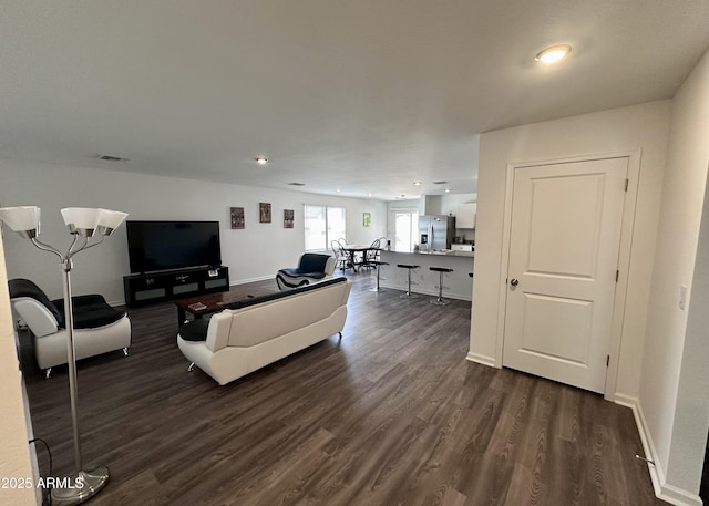 living room with dark wood-type flooring, recessed lighting, and baseboards