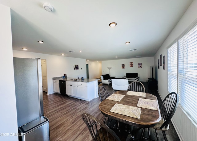 dining room with healthy amount of natural light, dark wood-style flooring, recessed lighting, and baseboards